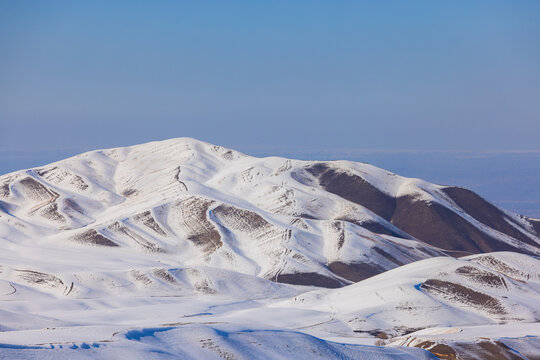 Vast Snow-Covered Mountain Range Under Clear Blue Sky