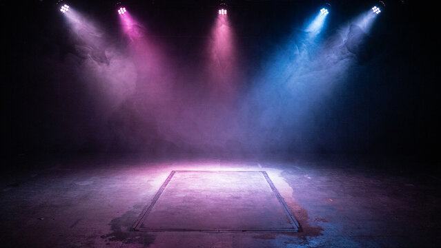 Dramatic stage lighting setup with colorful beams and fog creating an intense performance atmosphere