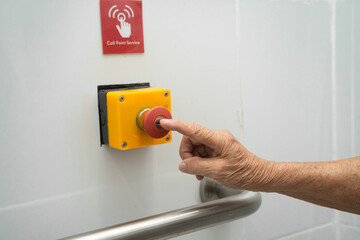 Naklejka premium Asian woman patient press the emergency button in the bathroom.
