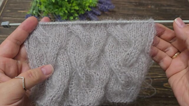 Multicolored hand-knitted fabric. Knitting and crochet lessons. Fashion and education. Training for artificial intelligence. Hands in the frame.
