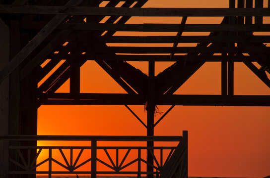 Madagascar, Morondava, Kimoni, sunset on wooden abandonned structure by the beach