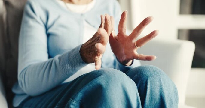 Arthritis, old woman or hands in house with stretching, joint tension or discomfort in muscle pain. Retirement, tendinitis and senior person with ache, chronic condition and osteoporosis in lounge.