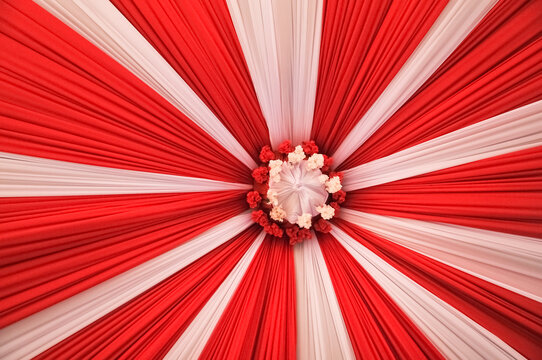 Red and white fabric tent ceiling decoration with radial sunburst pattern for Indonesian independence day celebration