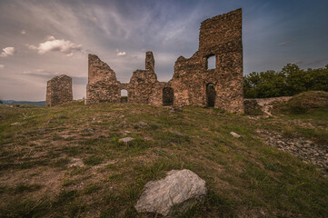 Ruins of medieval Brnicko castle standing on a grassy hill under dramatic sky in summer old stone fortress wall architecture landmark Moravia Czech Republic heritage travel photography © Rudolf