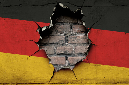 national flag of Germany is painted on an old wall with cracks