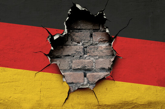 national flag of Germany is painted on an old wall with cracks