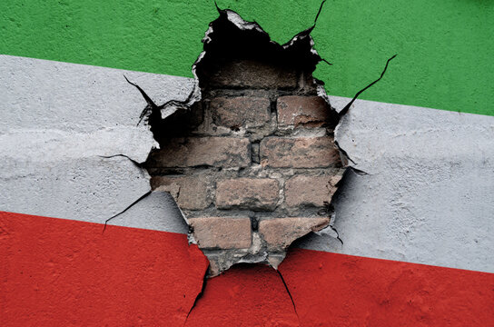 flag of the Islamic Republic of Iran are painted on an old wall with a cracked