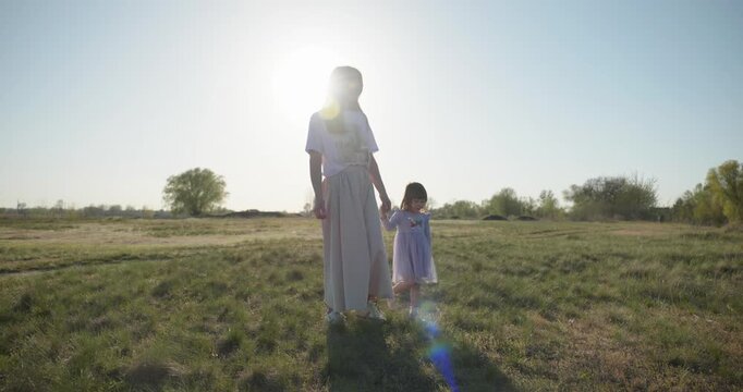 Young mother with child daughter spend time playing enjoying nature. 4K 10-bit