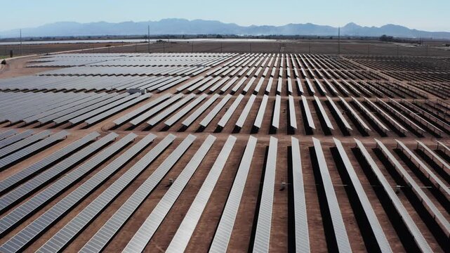 Vast Desert Solar Farm and Mountain Range Tilt-Down Reveal - Drone Aerial Shot - 4K UHD