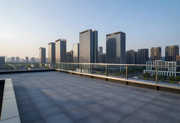 Fototapeta premium Empty rooftop terrace with modern glass railing overlooking a contemporary urban skyline at sunrise, Tall commercial and residential buildings rise against a clear morning sky, illuminated