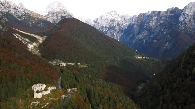 Aerial view of scenic Predil Pass beneath snow-capped peaks in the distance, Slovenia