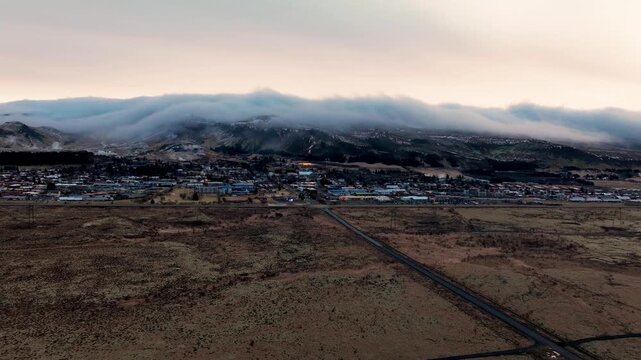 Drone hyperlapse over Hveragerdi in Iceland showing low clouds moving across the mountains, with views of the town, landscape and surrounding terrain