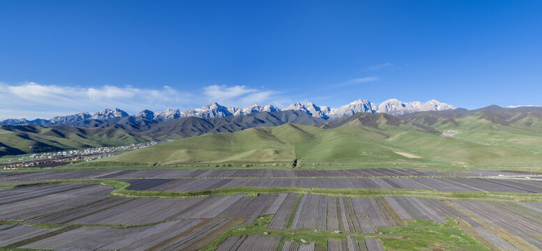 Maya Snow Mountain Rising Above Grasslands and Farmland, Gansu, China.