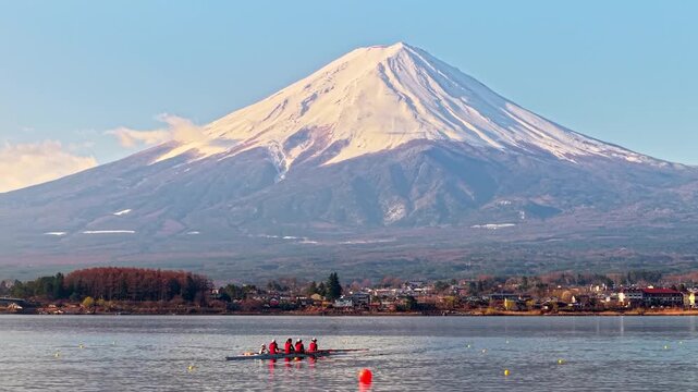 Rowing team practicing on lake Kawaguchi with majestic mount Fuji in background.