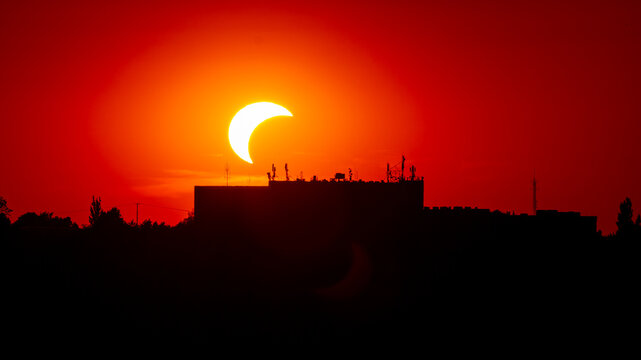 Partial solar eclipse sbove a city building | Częściowe zaćmienie słońca nad budynkiem miejskim
