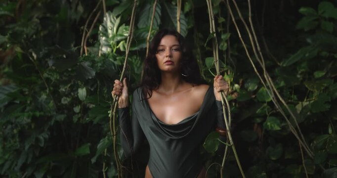 Seductive Woman in Jungle Posing Amidst Vines and Greenery