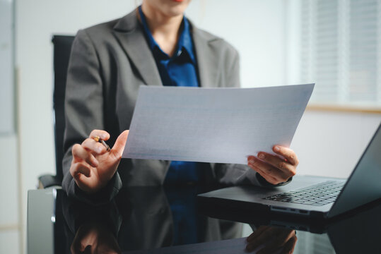 business documents on office desk with laptop and smart phone and graph business diagram and man working in morning light