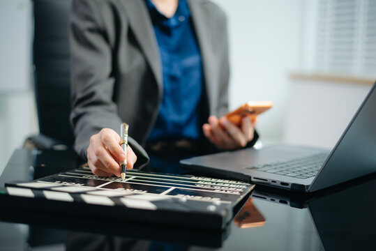 Creative filmmaker planning a video production project with a clapperboard, laptop and smartphone, representing filmmaking, content creation, media and digital storytelling.