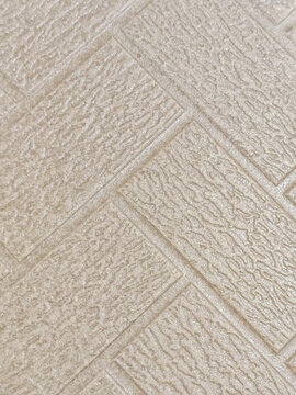 High resolution neutral beige embossed brick pattern textured wall surface background with realistic sheen and tactile detail. Tailored for interior designers, architects, 3D artists, graphic designer
