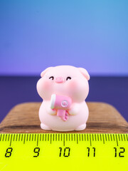 Close-up of a cute miniature pig figurine with bath accessories on a vibrant purple background. Adorable decorative ornament with playful details, perfect for home decor, crafts and collections. © Виталий Сова