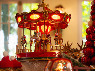 Illuminated red Christmas carousel music box with festive decoration © Oil And Den
