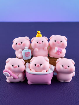 Close-up of cute miniature pig figurines with bath accessories on a vibrant purple background. 