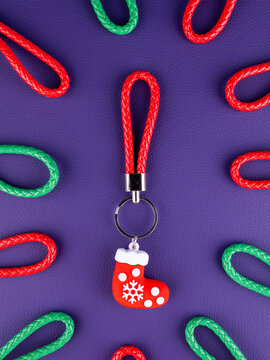 Close-up of a Christmas stocking keychain on a vibrant purple background. Festive holiday accessory with seasonal details, perfect for keys, bags, Christmas gifts, winter decorations and celebrations.