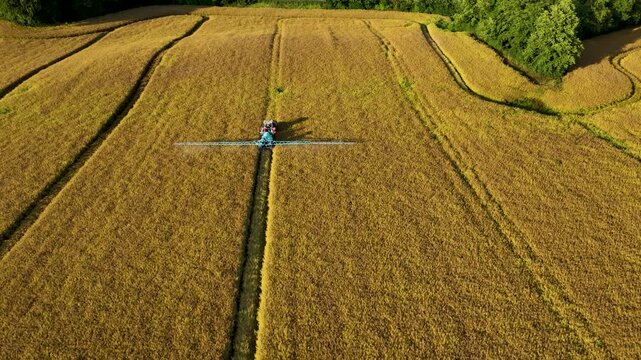 Symmetrical Aerial Shot of Boom Sprayer Straddling a Straight Field Ditch