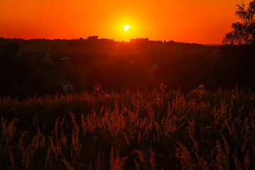 Partial solar eclipse above the countryside at sunset   Częściowe zaćmienie Słońca nad wsią o zachodzie słońca © Adrian White
