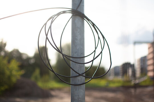 Coiled cable reserve attached to a utility pole, providing technological slack for installation