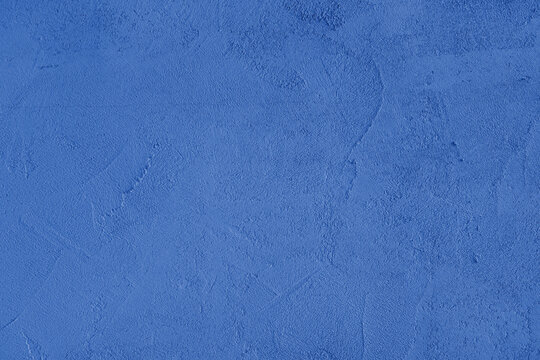 Blue stucco wall, uneven plaster surface, painted distressed concrete texture background. Abstract grunge backdrop, wallpaper for design, construction design element