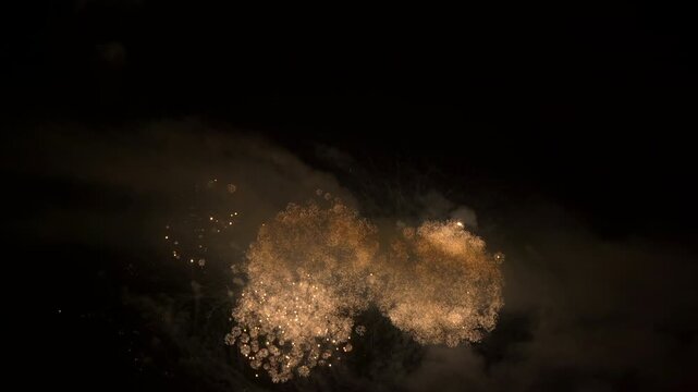 Beautiful fireworks isolated on a night sky in slow motion for an abstract background, ideal for anniversaries, celebrations or New Year's Eve.