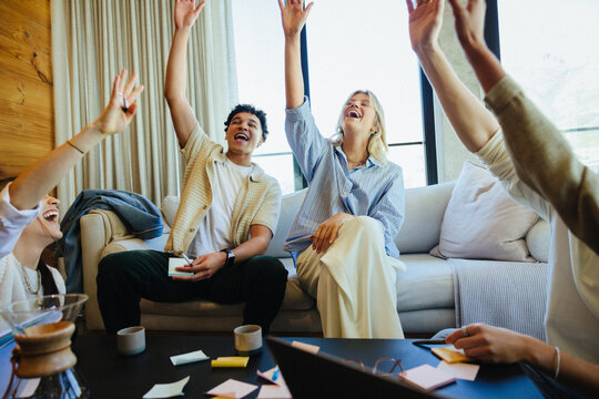 Group celebrating teamwork and achievements during a casual business meeting
