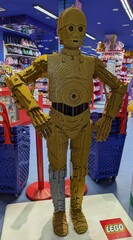 Fototapeta premium Enorme figura de exposición del robot C-3PO de Star Wars, construido con ladrillos de Lego, en la entrada de una juguetería Juguettos de Madrid, España, 3 de junio de 2026