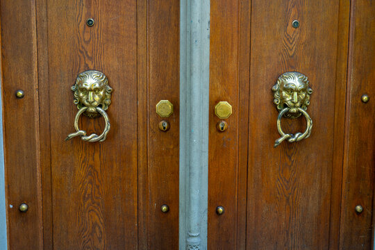 Brass Lion Head Door Knockers on Antique Wooden Double Doors in Old Town Zurich Switzerland. Masonic lodge Modestia cum Libertate.