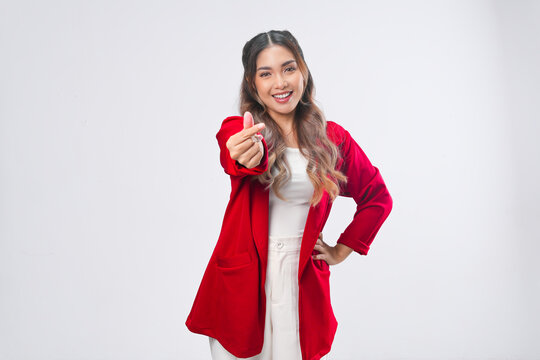 Lovely young Asian woman in a red jacket making a finger heart gestures.