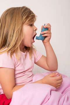 Young Girl Using an Asthma Inhaler at Home