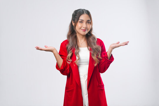 Beautiful young Asian woman in a red jacket is presenting the copy space beside her.