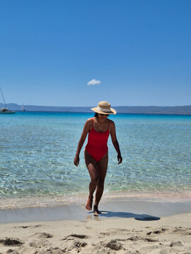 Stunning day at Simos Beach in Elafonissos, Greece, with a woman enjoying the crystal-clear waters