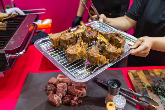 chef grills lamb ribs in a restaurant kitchen