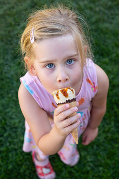 Smiling Little Girl Eating Ice Cream Outdoors