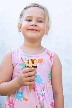 Little Girl Holding Ice Cream Cone and Looking at Camera