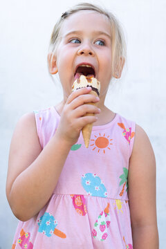 Little Girl Holding Ice Cream Cone and Looking at Camera