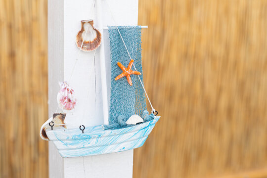 Decorative Sailboat with Starfish and Seashells on Wooden Background