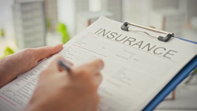 A female insurance agent fills out a property insurance form in a modern office. Property insurance concept. Property insurance claims consultation. Paperwork