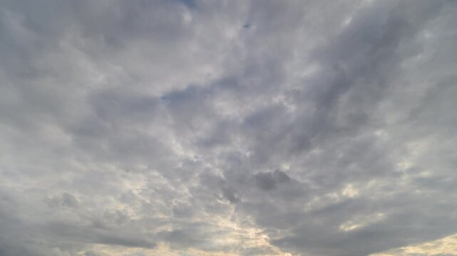 Wide sky clouds timelapse at twilight dense stratocumulus layers drifting slowly soft golden rim light near horizon lowangle drone perspective calm reflective mood