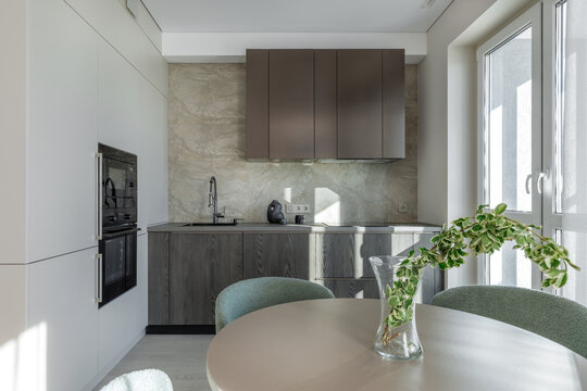 Modern Kitchen and Dining Area Interior with Round Table and Green Chairs
