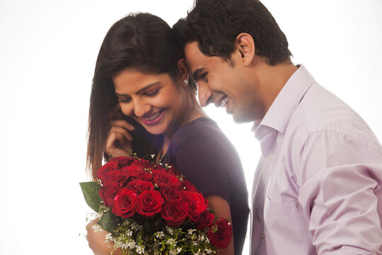 Couple with a bouquet of roses smiling