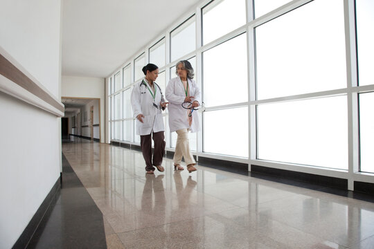 Two doctors in discussion walking down corridor