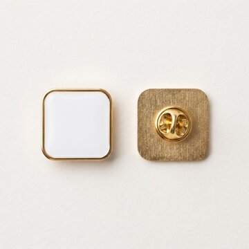 Lapel pin with a white square face and a gold metal fastener sits against a plain background.